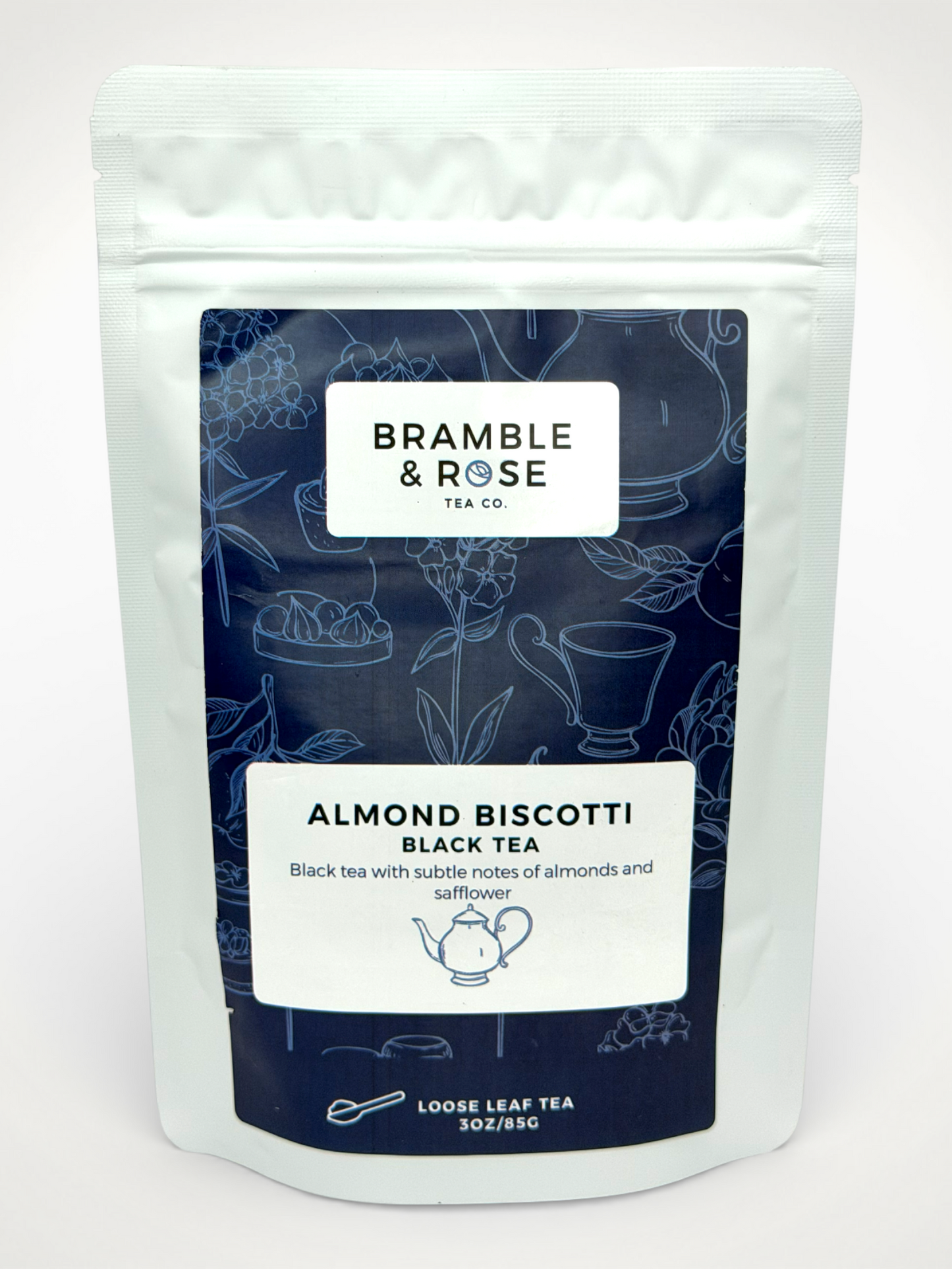 White pouch of Bramble & Rose Almond Biscotti Black Tea, with a dark blue design featuring tea themed illustrations, a white rectangle with product description, and the "Bramble & Rose" logo.