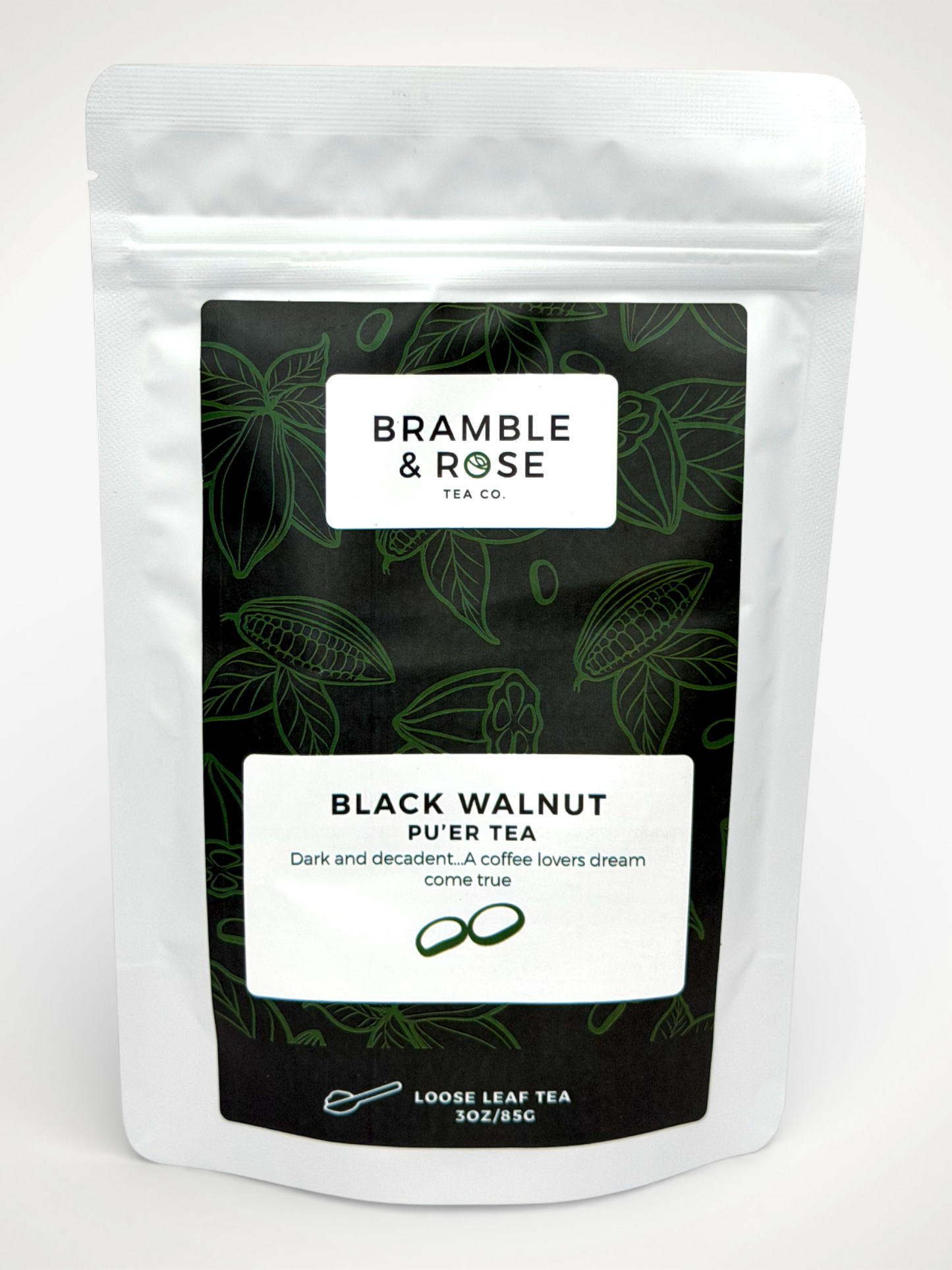 White pouch of Bramble & Rose Black Walnut Pu'er Tea, with a dark green label featuring tea leaf and cocoa pod illustrations, a white rectangle with product description, and the "Bramble & Rose" logo.