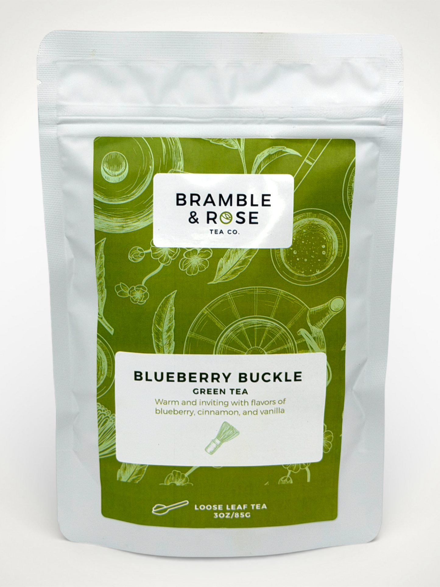 White pouch of Bramble & Rose Blueberry Buckle Green Tea, with a green label featuring asian tea themed illustrations, a white rectangle with product description, and the "Bramble & Rose" logo.