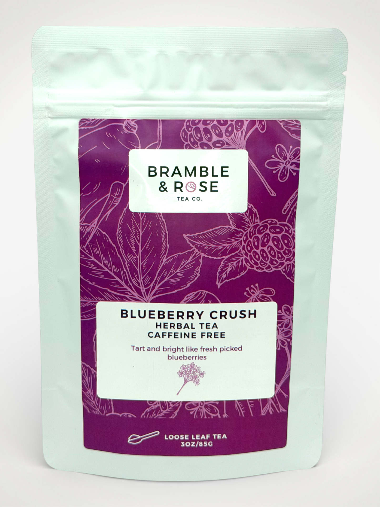 White pouch of Bramble & Rose Blueberry Crush Herbal Tea, with a deep berry label featuring fruit and plant illustrations, a white rectangle with product description, and the "Bramble & Rose" logo.