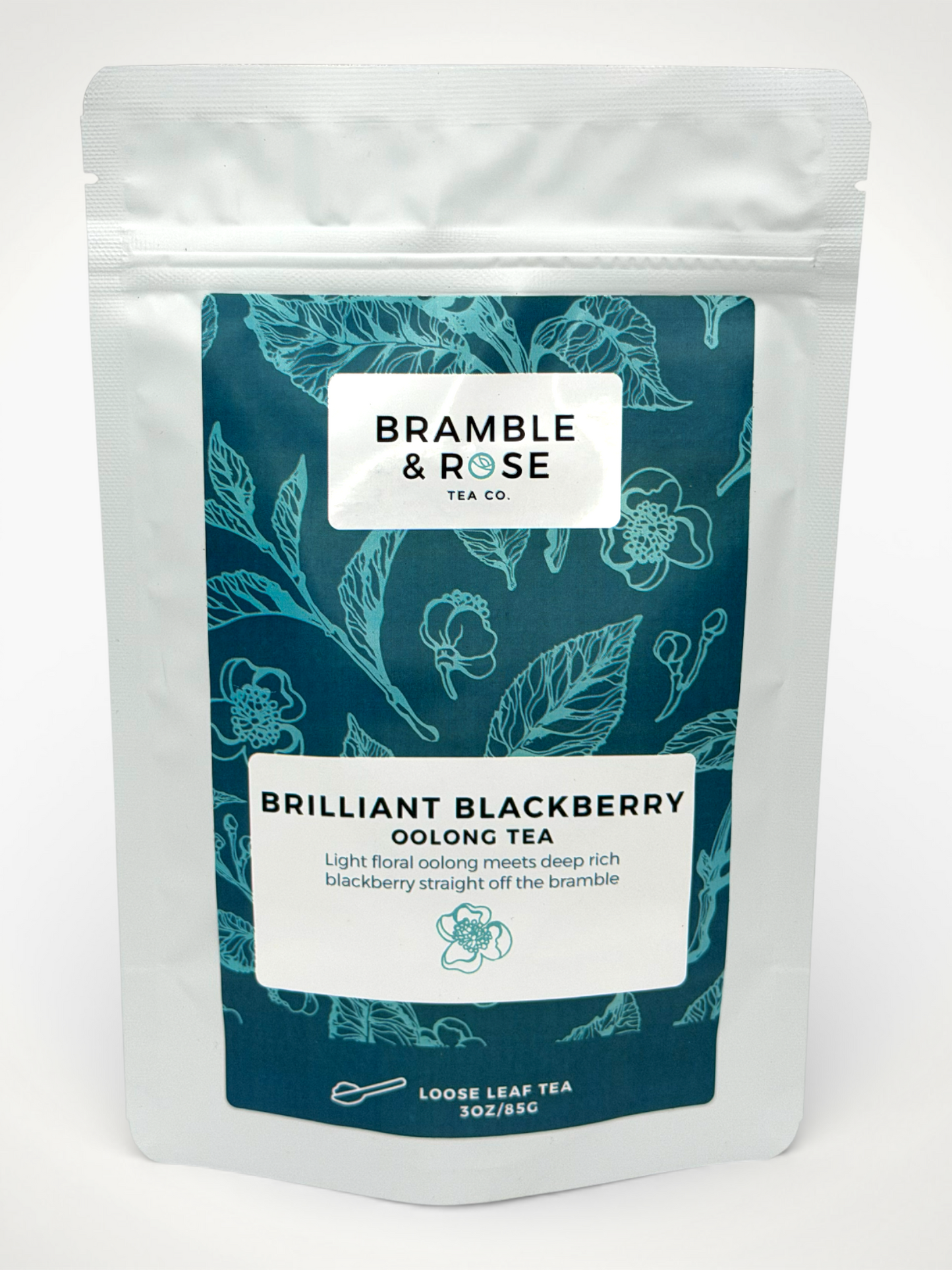 White pouch of Bramble & Rose Brilliant Blackberry Oolong Tea, with a teal label design featuring leaves and flowers, a white rectangle with product description, and the "Bramble & Rose" logo.