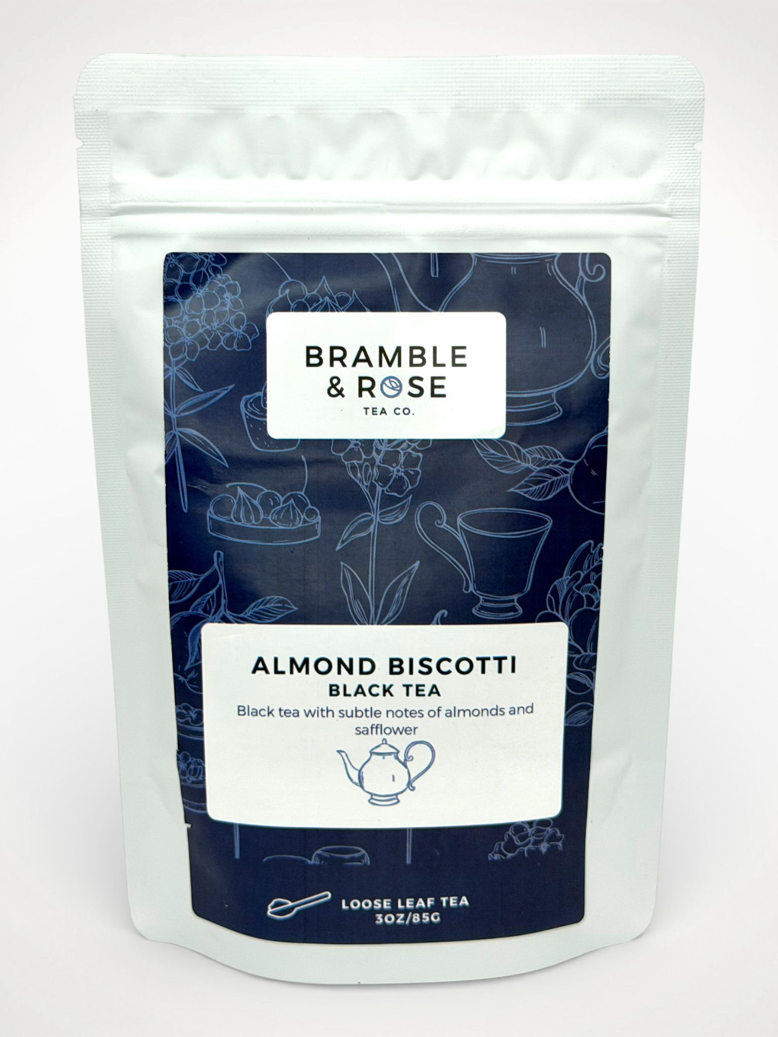White pouch of Bramble & Rose Almond Biscotti Black Tea, with a dark blue design featuring tea themed illustrations, a white rectangle with product description, and the "Bramble & Rose" logo.