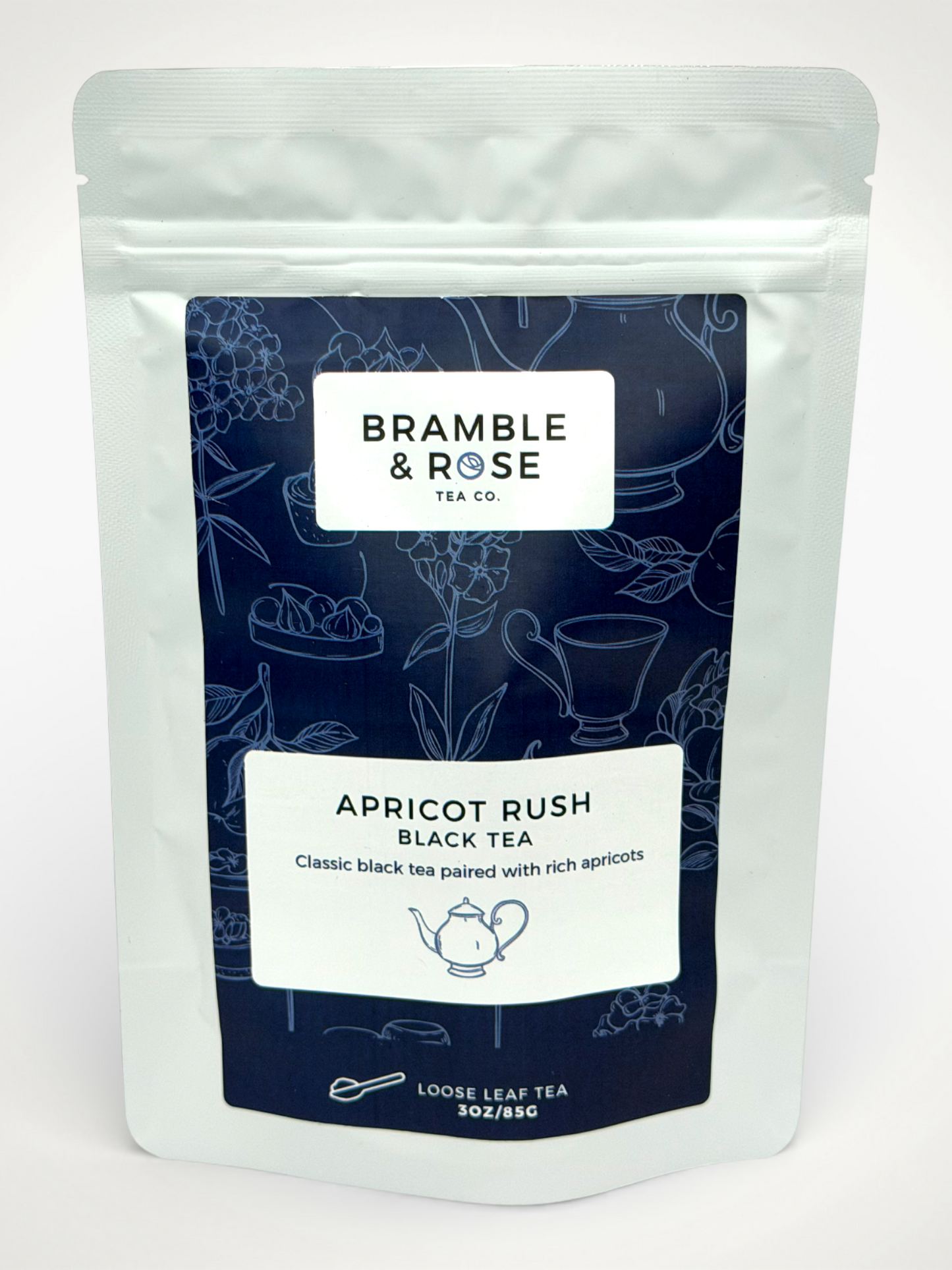 White pouch of Bramble & Rose Apricot Rush Black Tea, with a dark blue design featuring tea themed illustrations, a white rectangle with product description, and the "Bramble & Rose" logo.