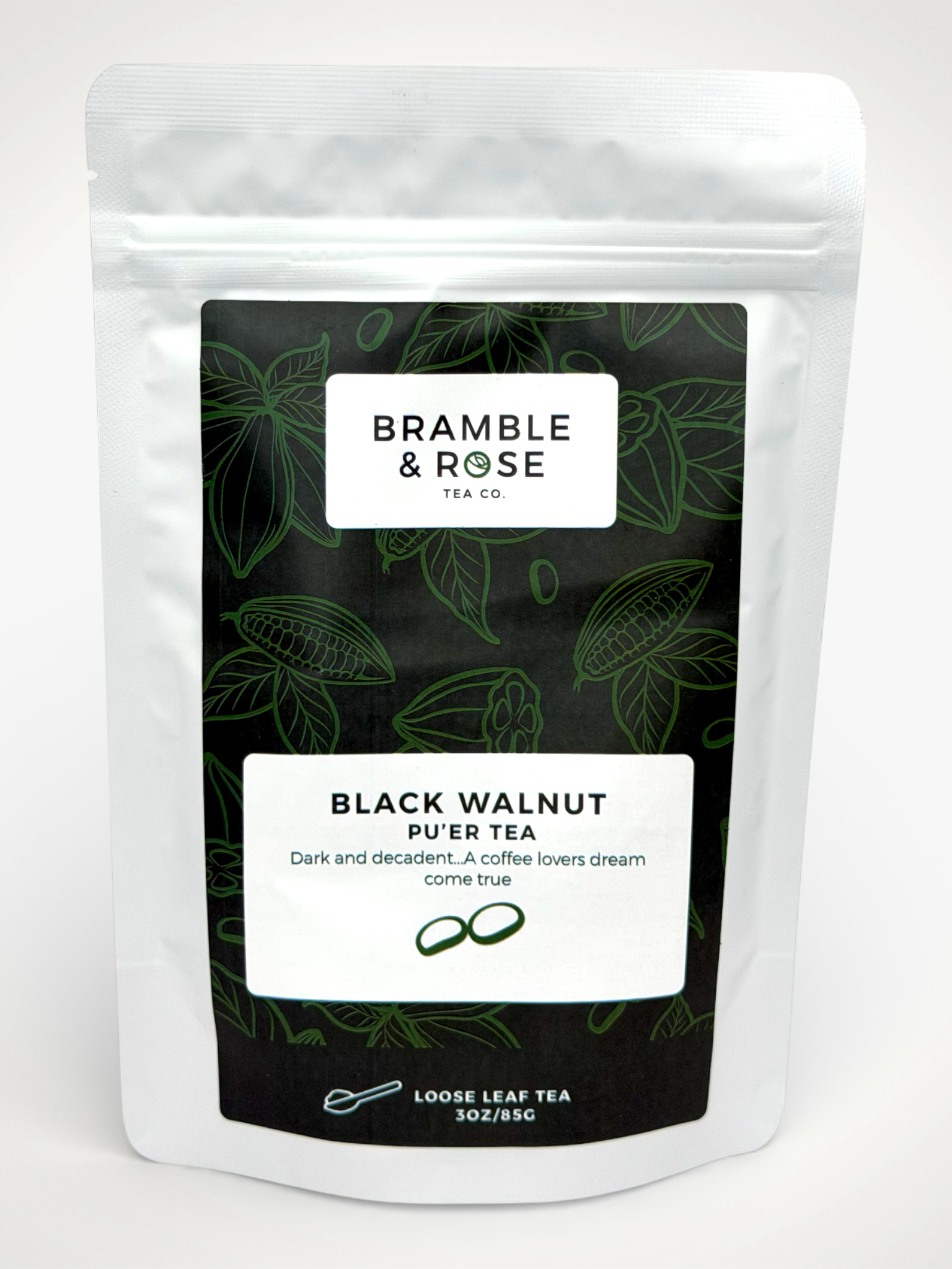 White pouch of Bramble & Rose Black Walnut Pu'er Tea, with a dark green label featuring tea leaf and cocoa pod illustrations, a white rectangle with product description, and the "Bramble & Rose" logo.