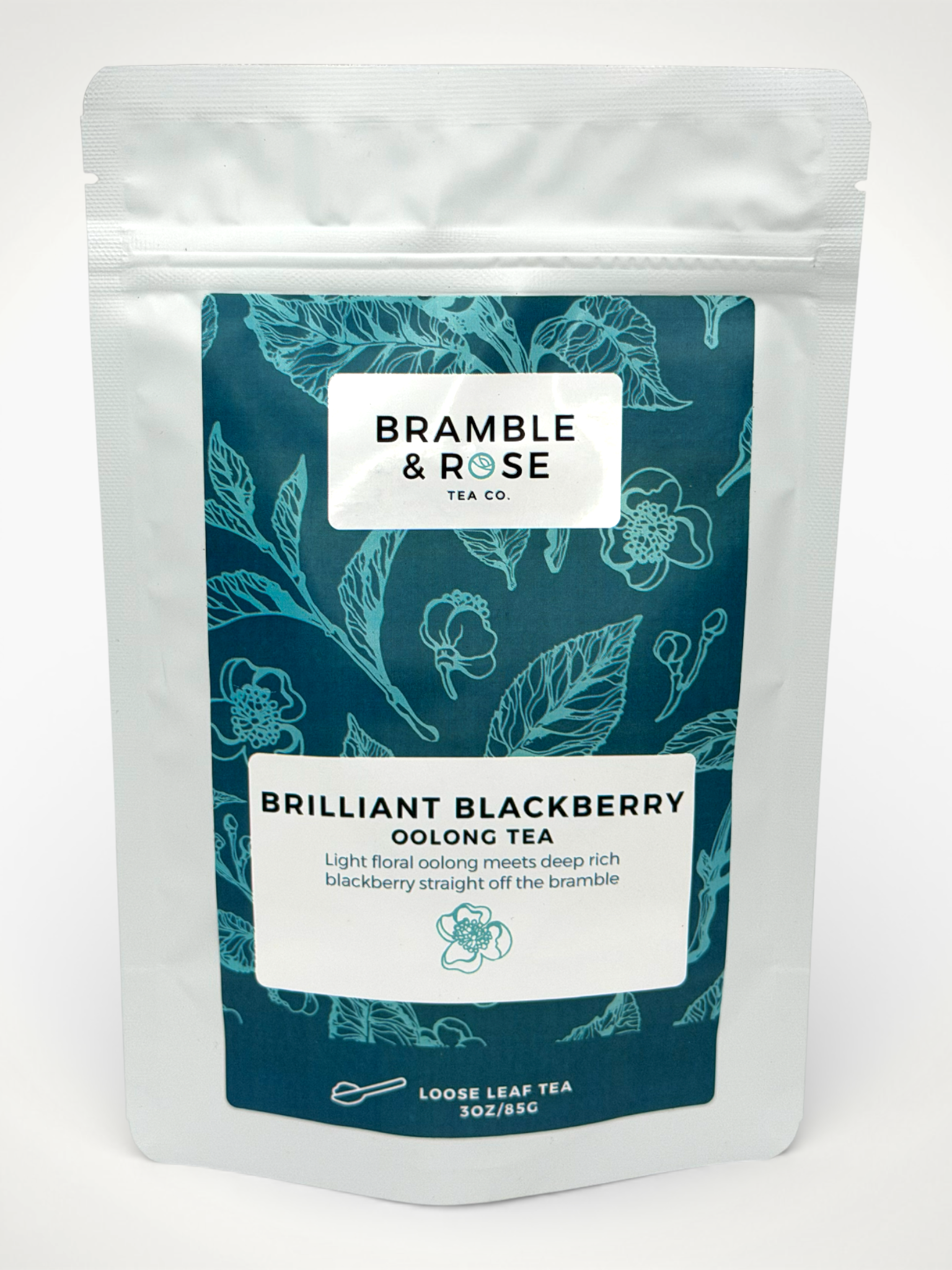 White pouch of Bramble & Rose Brilliant Blackberry Oolong Tea, with a teal label design featuring leaves and flowers, a white rectangle with product description, and the "Bramble & Rose" logo.