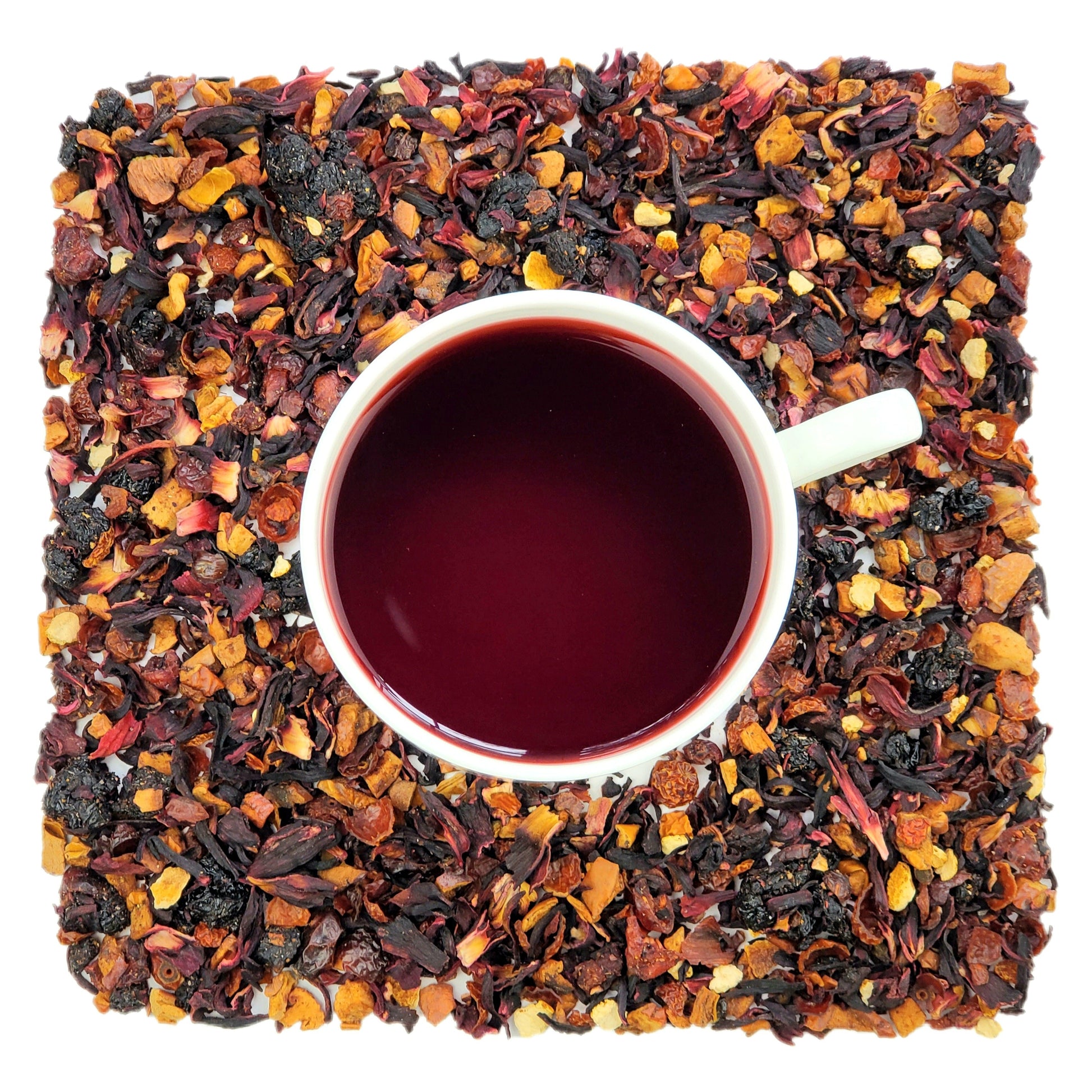 A cup of brewed herbal tea with visible dried fruit pieces around it, representing the tea's natural ingredients.