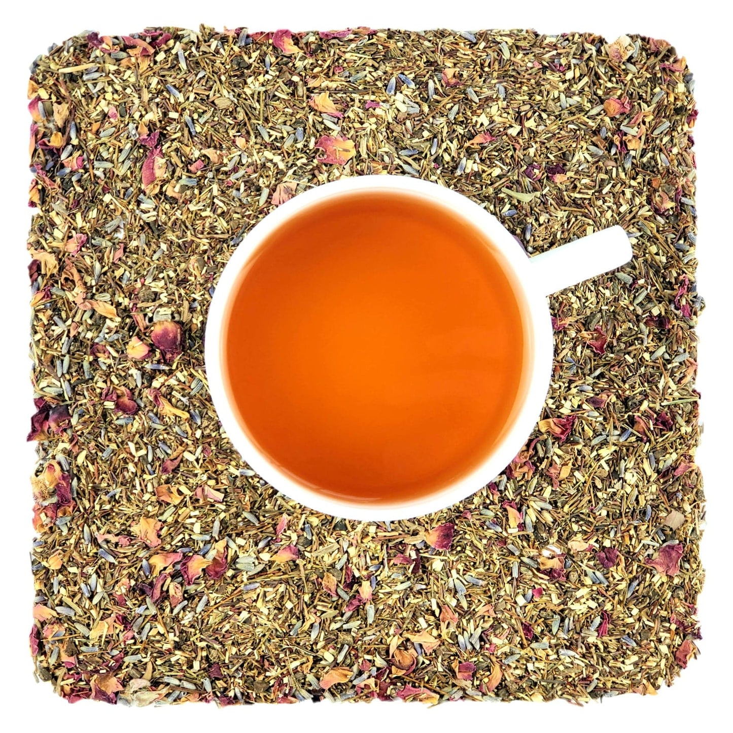 A cup of Sweet Slumber tea on a bed of dried Sweet Slumber tea leaves, which includes rooibos, valerian root, lavender, and rose petals.