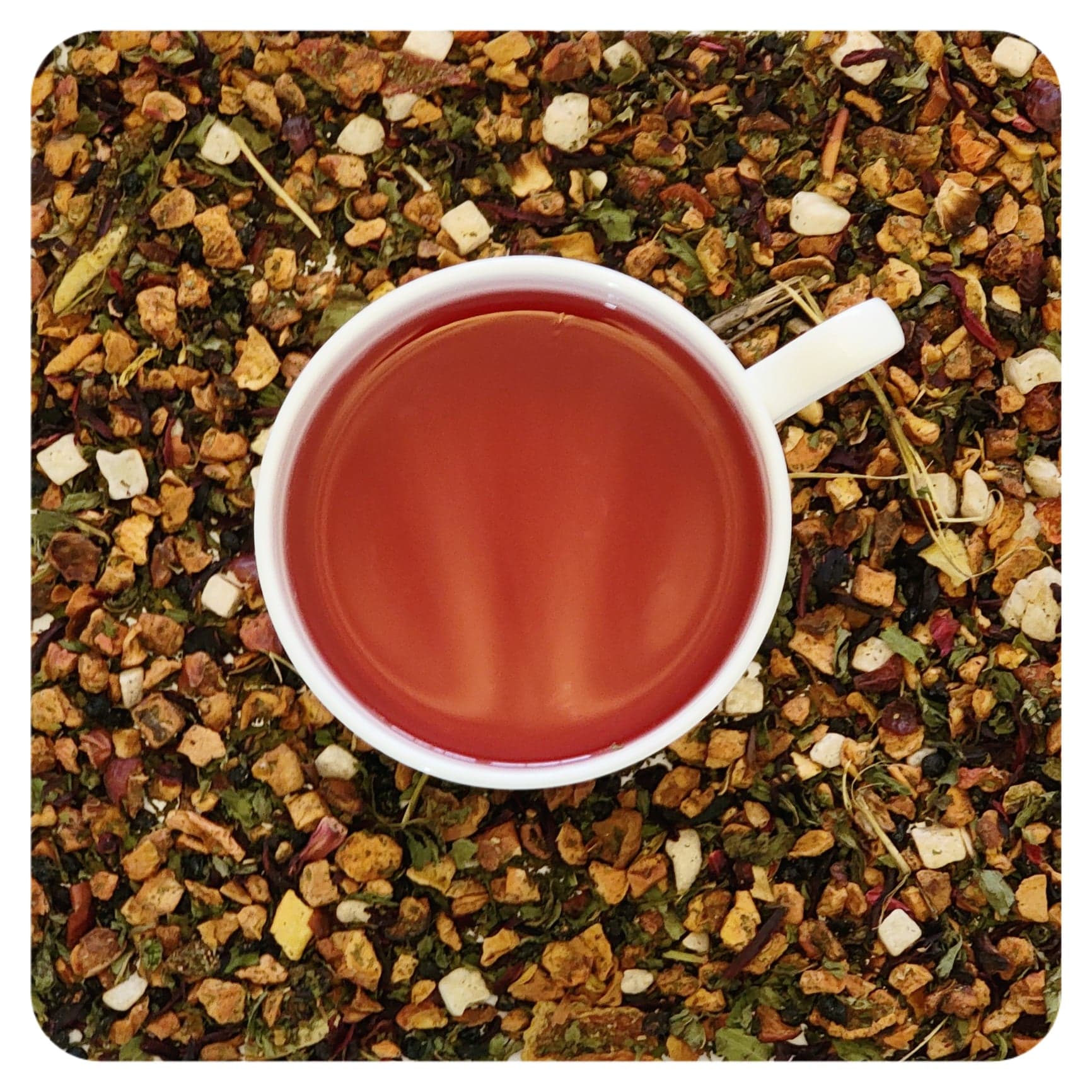 A cup of brewed watermelon cooler tea surrounded by pieces of dried watermelon, apple, honeydew, hibiscus, elderberry, peppermint, and rosehips.