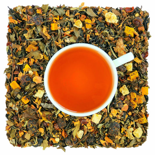 A cup of brewed Youth Berries tea on abed of dried white tea leaves, pieces of fruit, hibiscus flowers, rose petals, and berry pieces, indicating the ingredients of the tea.